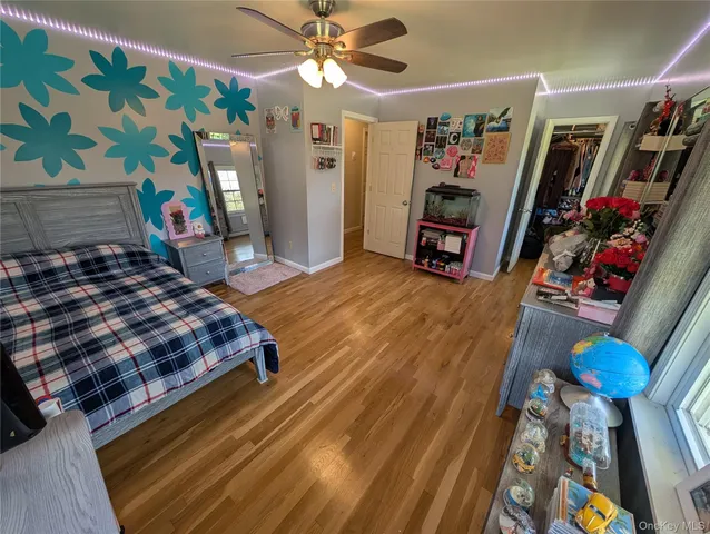 a bedroom with a bed bookshelf and a painting on the wall