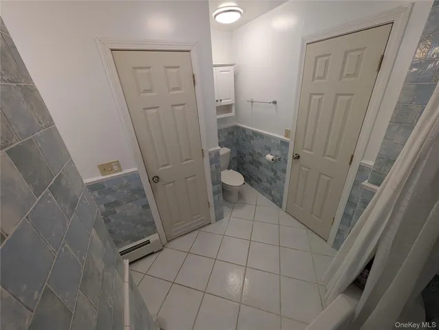 a bathroom with a granite countertop shower and a toilet