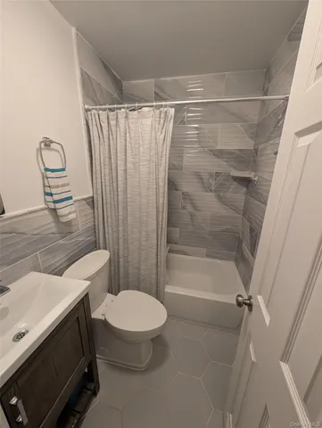 a bathroom with a shower a toilet and a sink