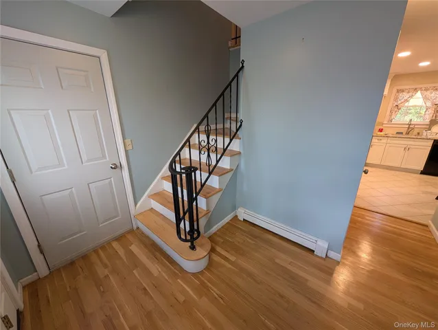 a view of a livingroom with wooden floor and staircase