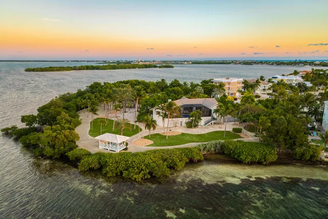 a front view of a house with a garden and trees