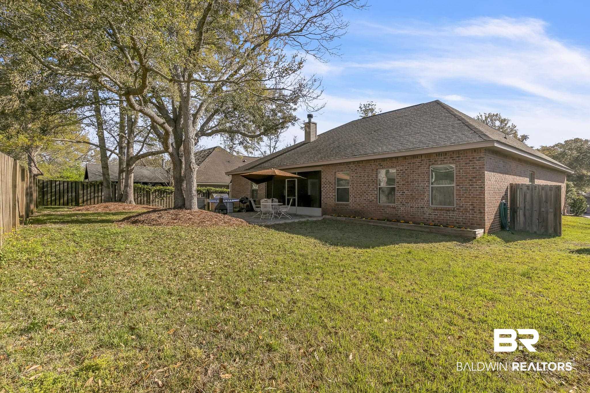 21439 Brick Stack Lane Fairhope, AL 36532 - Photo 31 of 32 Back of house featuring a lawn, brick siding, a chimney, and a patio area