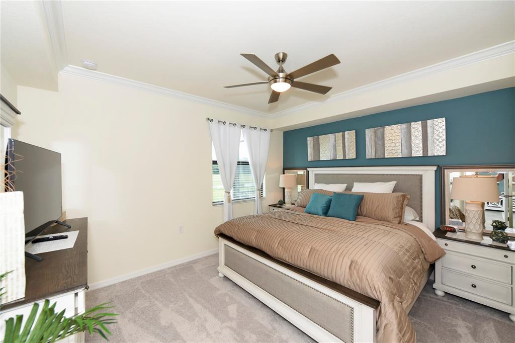 17810 Gawthrop Drive, Unit 101 Lakewood Ranch, FL 34211 - Photo 11 of 53 a bedroom with a large bed and a chandelier