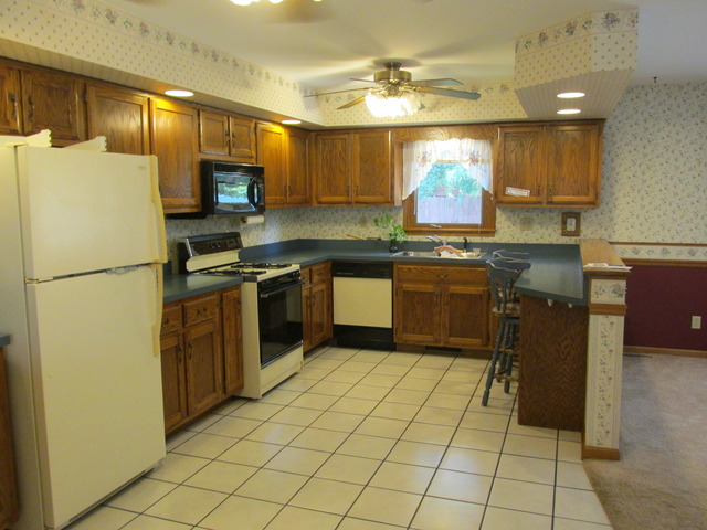 708 South Cooper Road New Lenox, IL 60451 - Photo 3 of 24 a kitchen with stainless steel appliances granite countertop a sink counter space cabinets and a refrigerator
