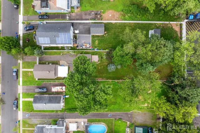 an aerial view of residential houses with outdoor space and swimming pool