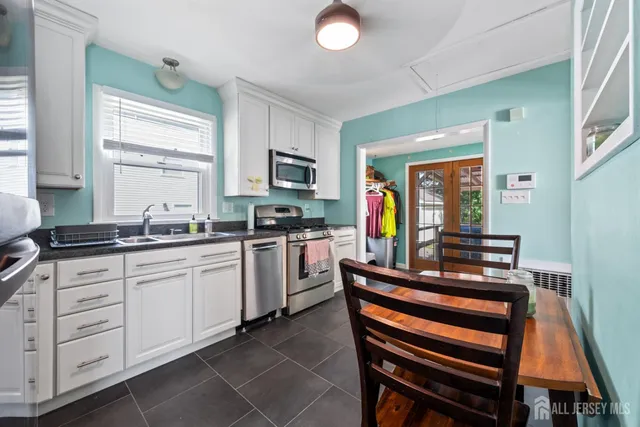 a kitchen with cabinets appliances and a window