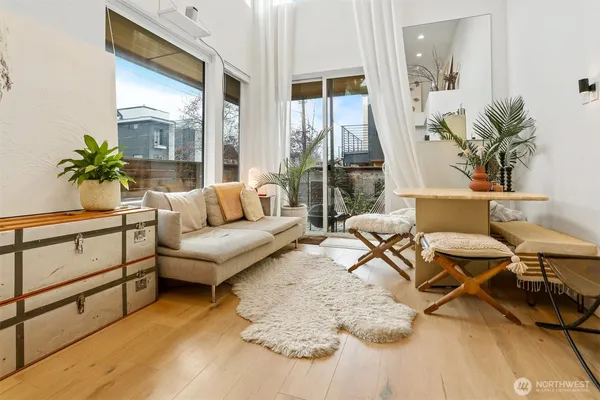 a living room with furniture potted plant and a large window