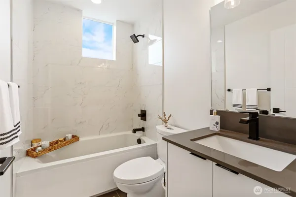 a bathroom with a sink a toilet a mirror and shower