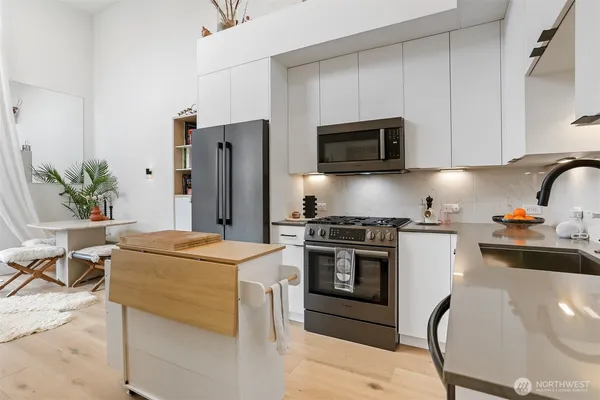 a kitchen with stainless steel appliances a stove refrigerator sink and microwave