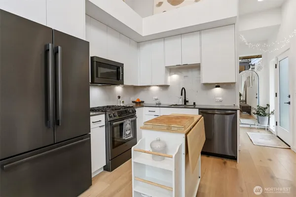 a kitchen with stainless steel appliances granite countertop a refrigerator stove and sink