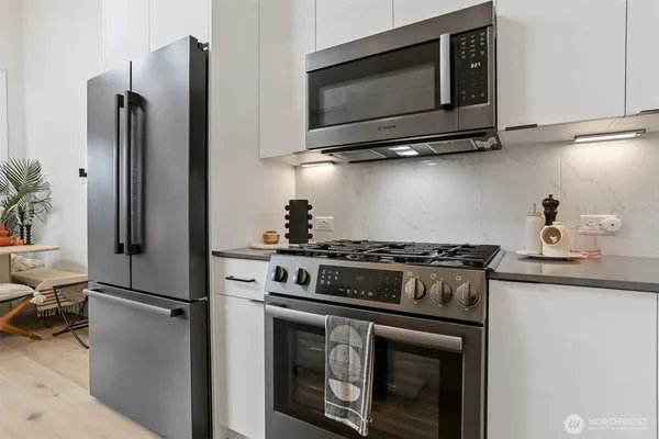 a kitchen with stainless steel appliances granite countertop a stove microwave and refrigerator