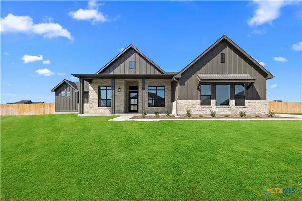 a front view of a house with yard and green space