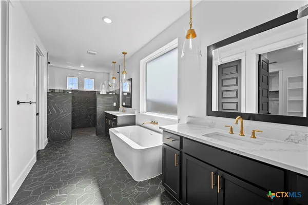 a bathroom with a double vanity sink mirror and bathtub