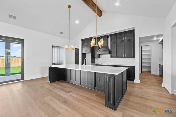 a kitchen with stainless steel appliances wooden floor sink and wooden cabinets