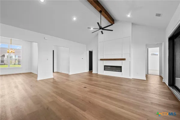 a view of empty room with wooden floor and fireplace