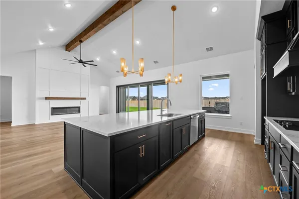 a kitchen with a stove and a wooden floor