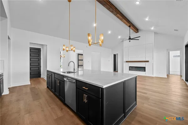 an open kitchen with a sink and dishwasher a oven with wooden cabinets