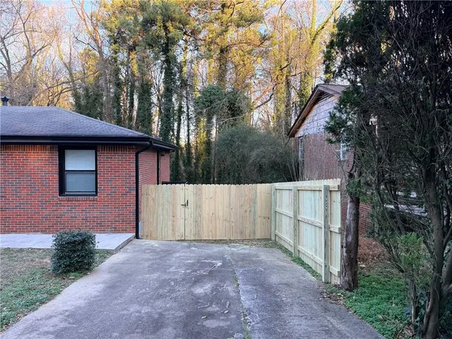 a view of backyard of house with large trees