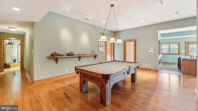 a kitchen with stainless steel appliances granite countertop a sink dishwasher a stove and a refrigerator with wooden floor