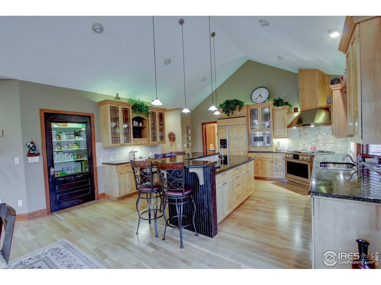 7848 Eagle Ranch Road Fort Collins, CO 80528 - Photo 11 of 46 a kitchen with stainless steel appliances kitchen island granite countertop a table chairs and a refrigerator