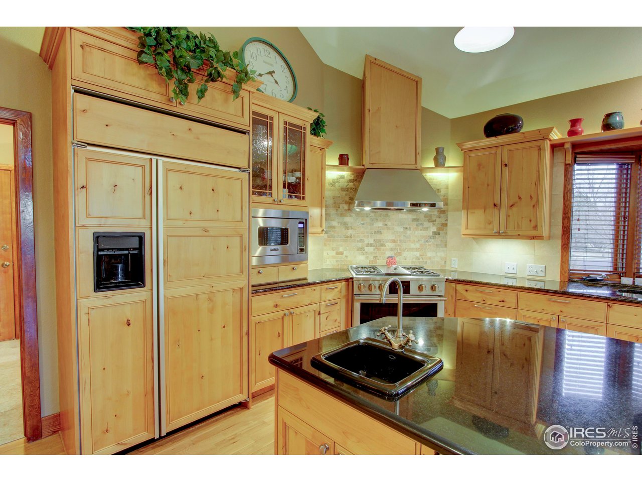 7848 Eagle Ranch Road Fort Collins, CO 80528 - Photo 12 of 46 a kitchen with stainless steel appliances kitchen island granite countertop a refrigerator and a stove