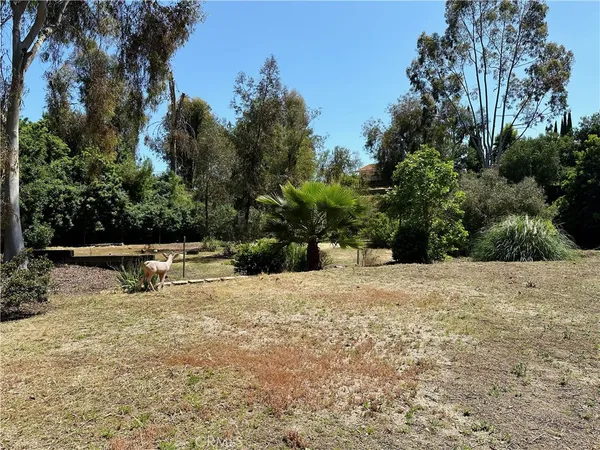 a view of backyard with swimming pool and seating space