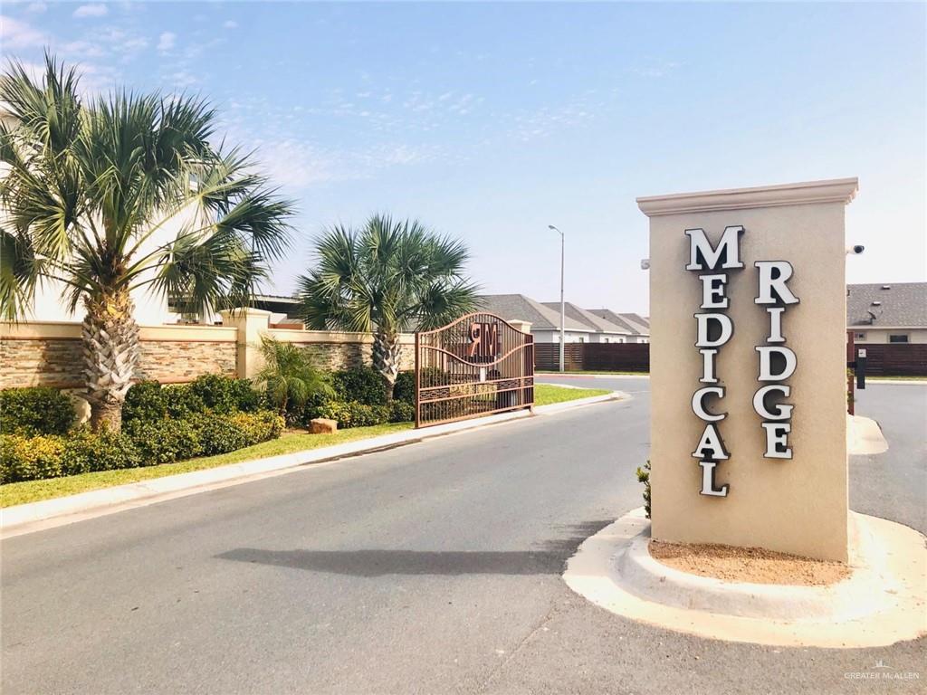 1716 West Garrison Drive, Unit 2 Pharr, TX 78577 - Photo 2 of 17 View of asphalt road featuring a gated entry, curbs, a gate, and street lighting