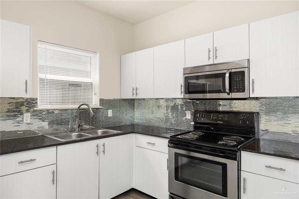 1716 West Garrison Drive, Unit 2 Pharr, TX 78577 - Photo 4 of 17 Kitchen with appliances with stainless steel finishes, decorative backsplash, white cabinetry, and dark stone countertops