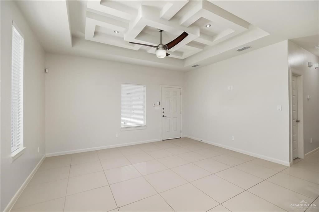 1716 West Garrison Drive, Unit 2 Pharr, TX 78577 - Photo 5 of 17 Empty room with a ceiling fan, coffered ceiling, light tile patterned flooring, and beam ceiling