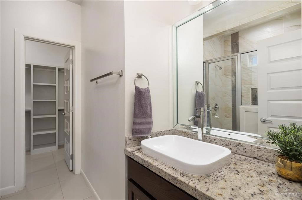 1716 West Garrison Drive, Unit 2 Pharr, TX 78577 - Photo 8 of 17 Bathroom with a shower stall, vanity, a walk in closet, and light tile patterned floors