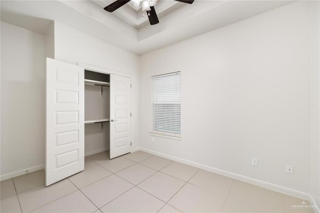 1716 West Garrison Drive, Unit 2 Pharr, TX 78577 - Photo 10 of 17 Unfurnished bedroom featuring light tile patterned floors, a closet, and a ceiling fan