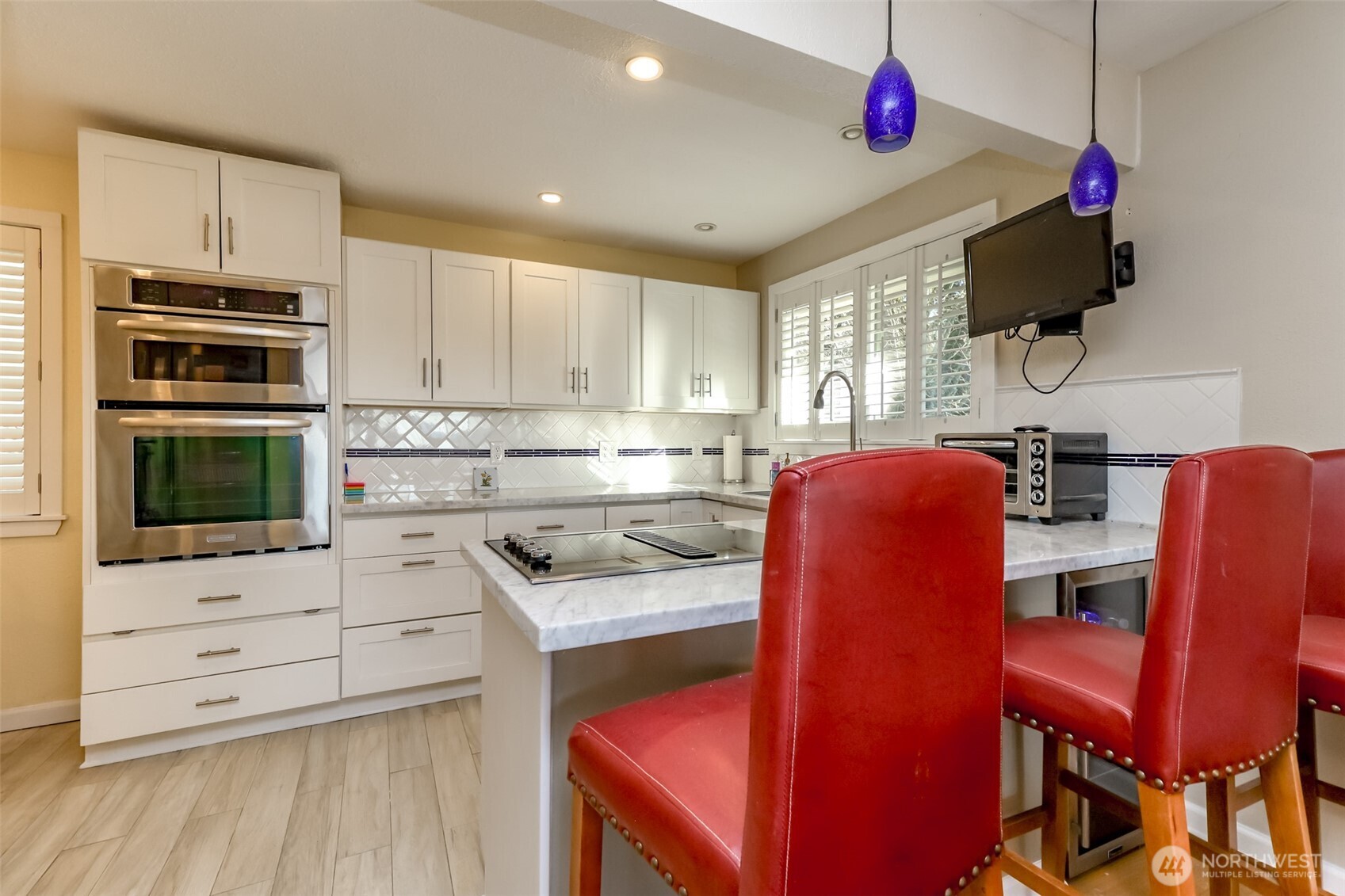 2424 Southwest 152nd Street Burien, WA 98166 - Photo 14 of 39 a kitchen with stainless steel appliances kitchen island granite countertop a stove top oven a sink dishwasher a dining table and chairs with wooden floor