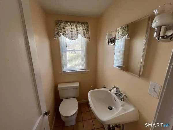 a bathroom with a toilet a sink and mirror
