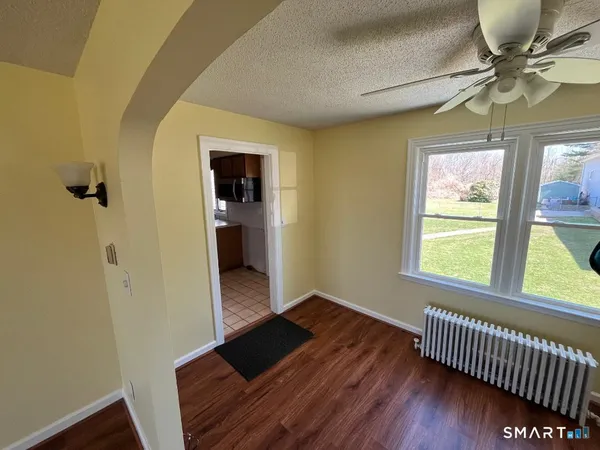 a view of empty room with wooden floor
