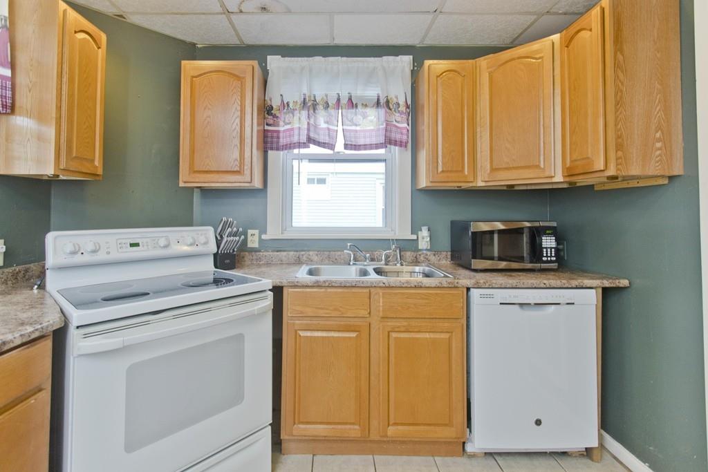 107 Ardmore Street Springfield, MA 01104 - Photo 6 of 30 a kitchen with stainless steel appliances granite countertop a sink and cabinets with wooden floor