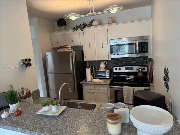 a kitchen with metallic refrigerator and microwave