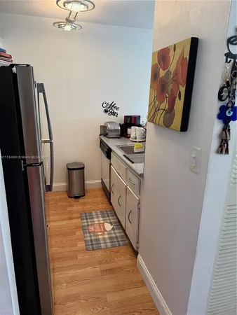 a kitchen with a refrigerator and a stove top oven