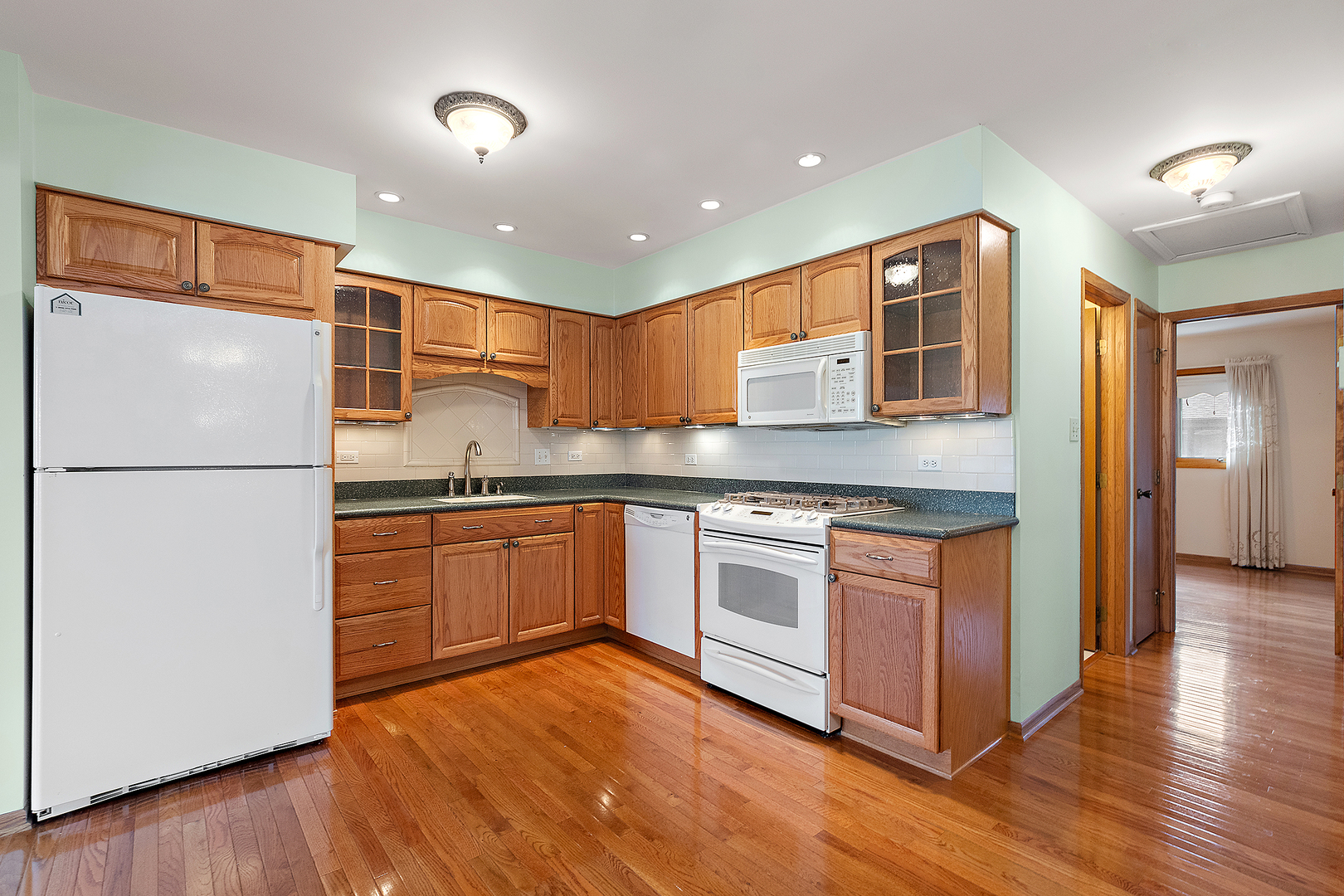 10459 Eagle Ridge Drive, Unit 139 Orland Park, IL 60467 - Photo 12 of 25 a kitchen with stainless steel appliances granite countertop a refrigerator a sink dishwasher a stove and white countertops with wooden floor