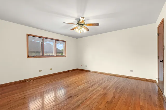 an empty room with fireplace cabinet and windows