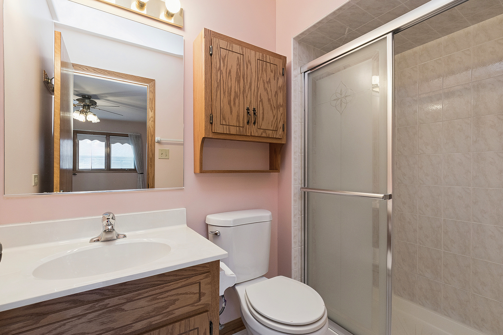 10459 Eagle Ridge Drive, Unit 139 Orland Park, IL 60467 - Photo 16 of 25 a bathroom with a sink a toilet a mirror and shower