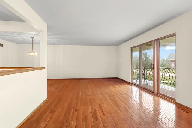 a dining room with furniture a chandelier and wooden floor