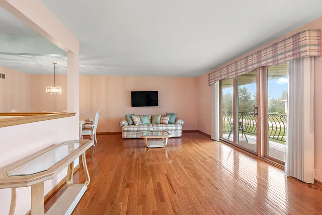 a kitchen with stainless steel appliances kitchen island granite countertop a dining table chairs and white cabinets