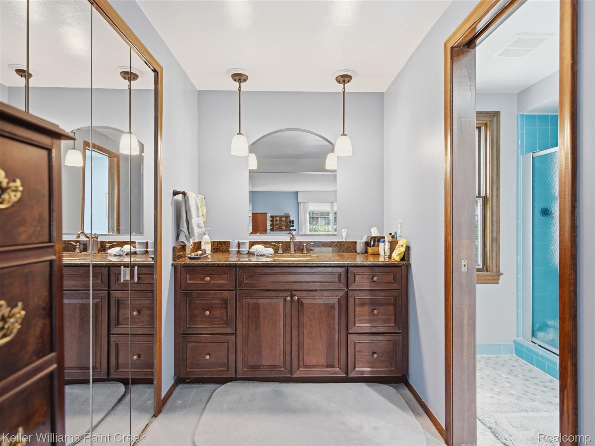 2950 Leyton Court Rochester, MI 48306 - Photo 27 of 46 Double vanity with a stone-finish countertop, dual basin sinks, and pendant lighting