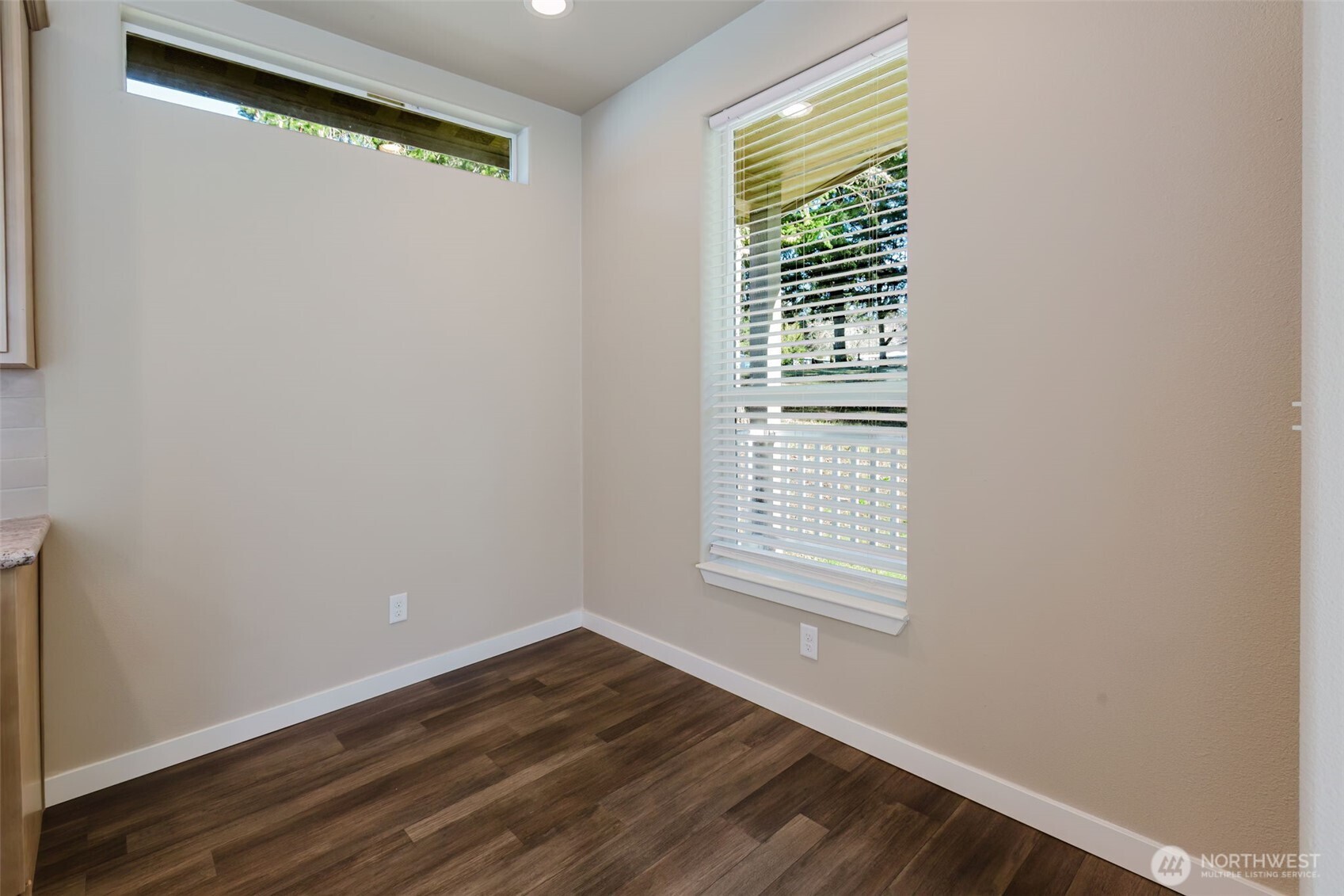 3371 Southeast Bielmeier Road, Unit 95 Port Orchard, WA 98367 - Photo 17 of 40 a view of an empty room with wooden floor and a window