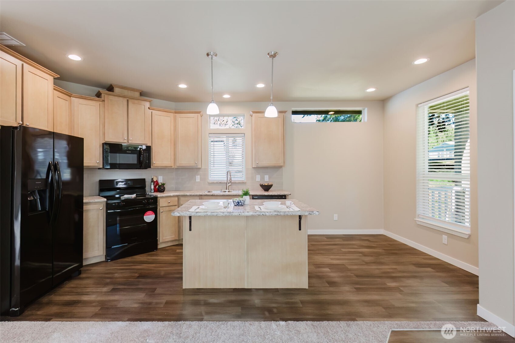 3371 Southeast Bielmeier Road, Unit 95 Port Orchard, WA 98367 - Photo 23 of 40 a kitchen with kitchen island a refrigerator stove a sink and a oven with wooden floor