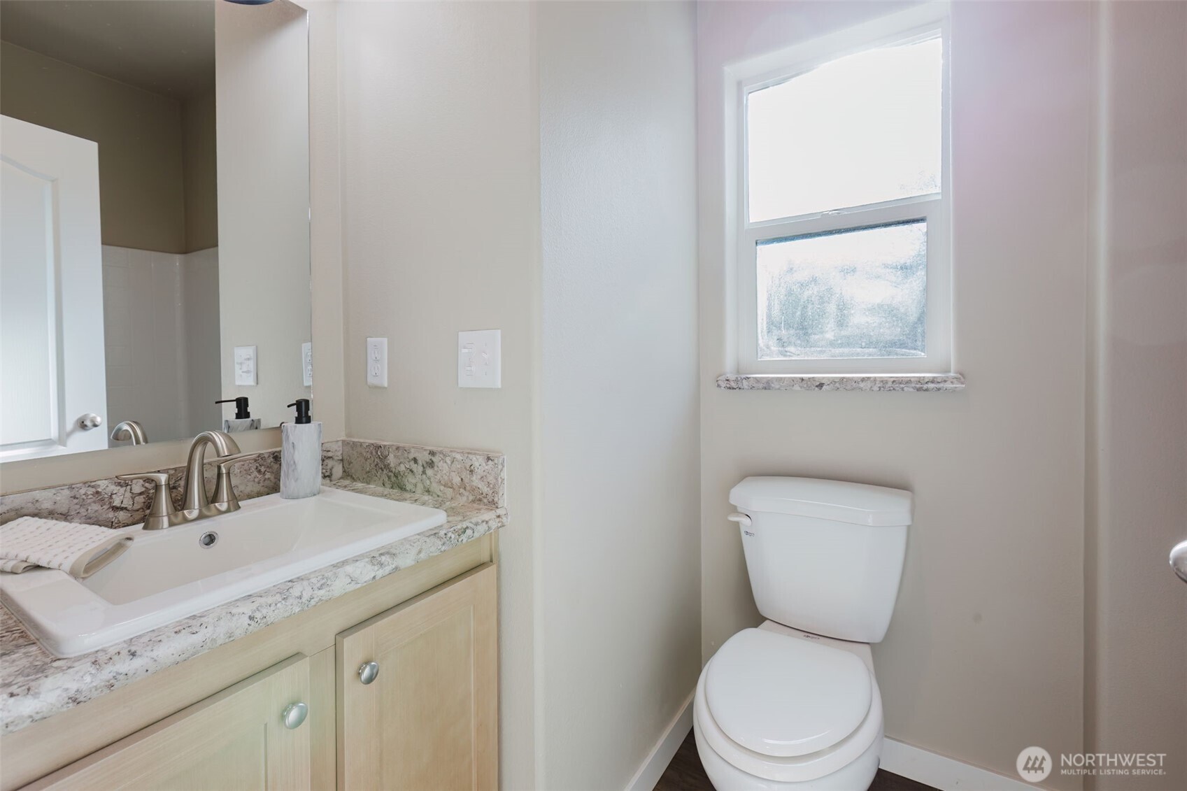 3371 Southeast Bielmeier Road, Unit 95 Port Orchard, WA 98367 - Photo 29 of 40 a bathroom with a granite countertop toilet a sink and a window