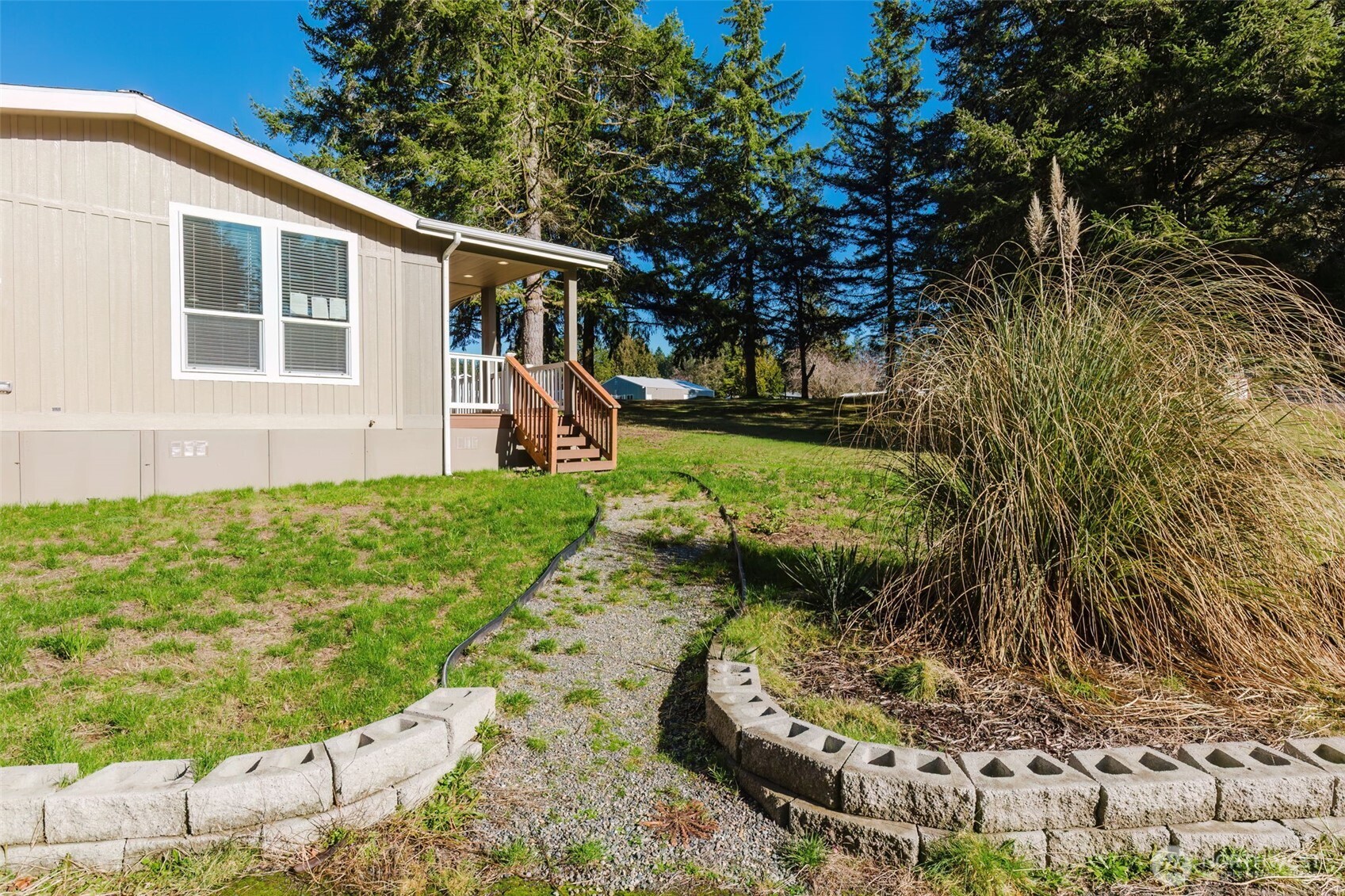 3371 Southeast Bielmeier Road, Unit 95 Port Orchard, WA 98367 - Photo 8 of 40 a view of a backyard with plants and large tree