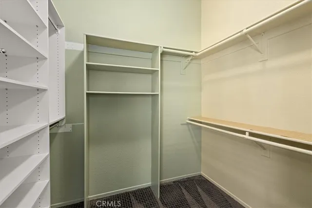 a view of walk in closet with empty racks