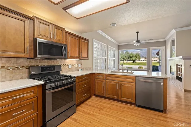 a kitchen with stainless steel appliances granite countertop wooden cabinets stove top oven and sink