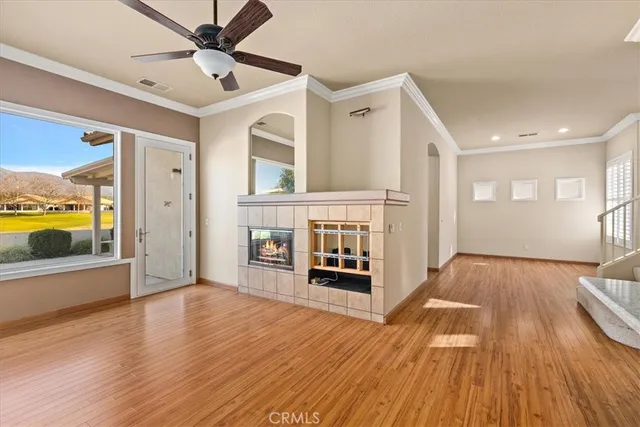 a view of a livingroom with wooden floor and a ceiling fan